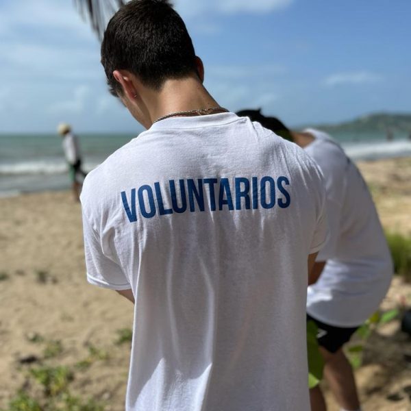 Voluntarios en la playa con camisetas de Huellas de Salud